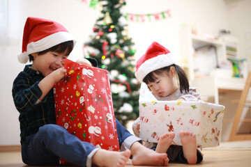 クリスマスプレゼントを開ける子供たち