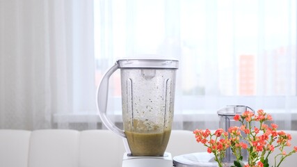 Close-up of healthy green smoothie, detox cocktail preparing in blender