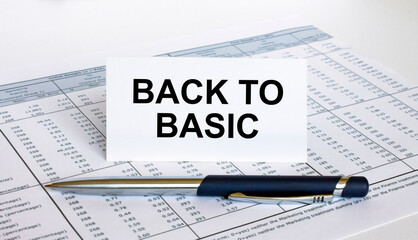 Text Back To Basic on white card with blue metal pen on financial table