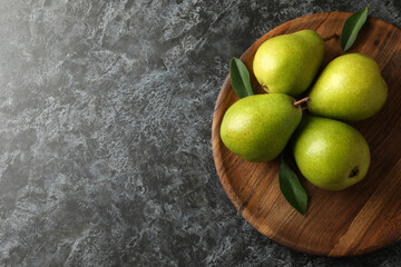 Wooden tray with green pears on black smokey background - Powered by Adobe