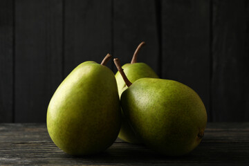 Fresh green pears on wooden background, close up