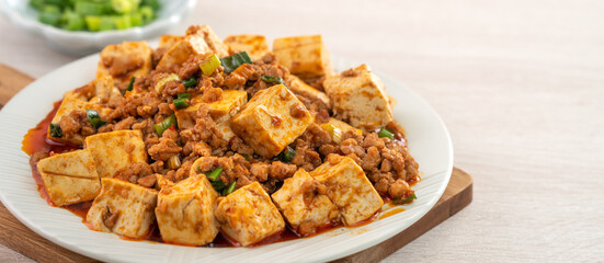 Mapo tofu, stir-fried tofu with hot spicy sauce in white plate.