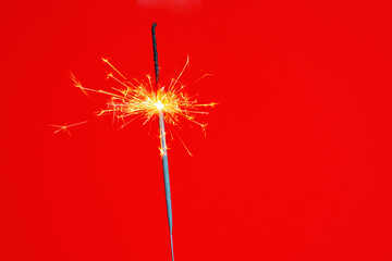 Day of sparklers. Sparkling Sparkler on red background. Copy space. Concept of holidays and celebration