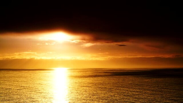 Seascape. Dramatic sunset over sea with dark clouds moving over water surface, time lapse. Nature evening landscape.