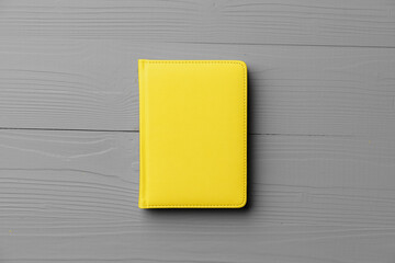 Yellow notepad on gray wooden background top view