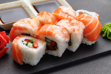 Sushi roll covered with salmon and prawn close up
