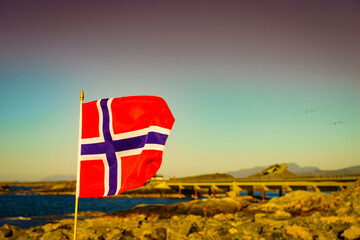 Norwegian flag against Atlantic Road, Norway