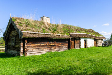 Obraz premium Idyllic old log cottage with thatched roof