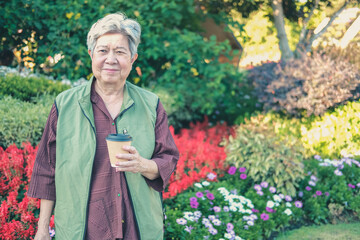asian old elderly elder woman drinking coffee tea in garden. senior leisure lifestyle