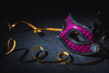 Carnival mask with golden ribbon on black background