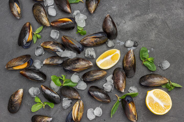 Mussels with lemon and ice, mint are scattered on table