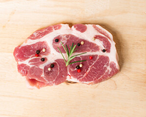 Raw meat with spices in wooden board isolated on wood background.