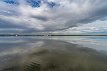 Flooded rice fields under cloudy sky reflection