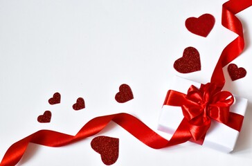 Valentine's Day card. Gift box with red ribbon and hearts on a white background. Holiday concept. 