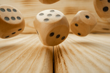 Wooden dice tossed on wooden background close up