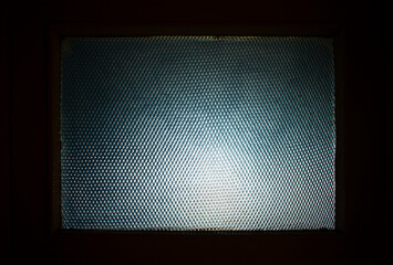 Textured glass or plexiglass (vertical or mesh pattern) with dim light outside wiev  