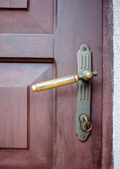 Wooden vintage brown lacquered doors with metal rustic door handle and the key