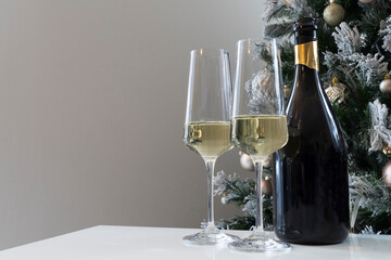Christmas holiday table with glasses and a bottle of wine of champagne. Eve of new year, preparation and laying of a holiday table.
