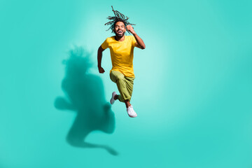 Obraz premium Full size photo of young excited smiling cheerful happy afro man jumping running isolated on turquoise color background