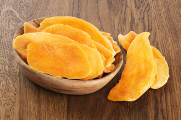 Dried mango on wooden background.