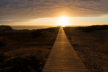 wooden boardwalk at sunset, coastal landscape Carrapateira West Algarve. cloudy sky