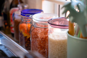 Nice bottle glass foods container near the kitchen window close up