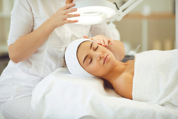 Good-looking young female getting professional skin treatment in modern beauty salon