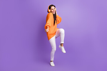 Fototapeta na wymiar Full size photo of optimistic funky girl dance listen song wear red sweater trousers sneakers isolated on lilac background
