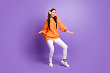 Fototapeta na wymiar Full size photo of optimistic funky girl dance listen music wear red sweater trousers sneakers isolated on lilac background