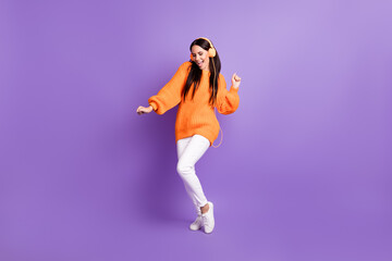 Fototapeta na wymiar Full size photo of optimistic nice girl dance listen music wear red sweater trousers sneakers isolated on lilac background