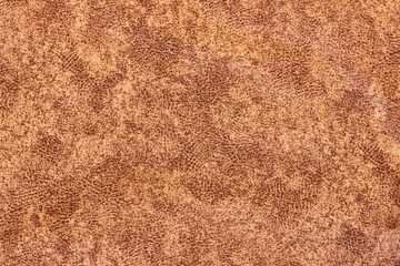 The structure of a brown fabric with a fine variegated pattern.