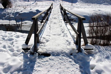 Snow covered old wooden bridge