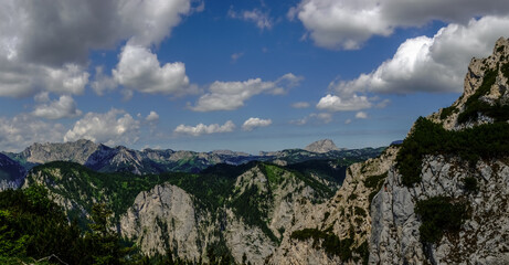 rocky mountains with green trees and shrubs while hiking in the summer panorama