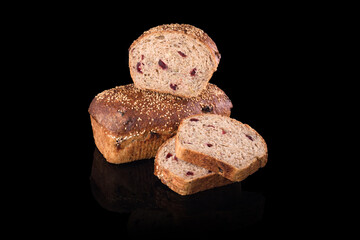 Freshly baked homemade bread isolated on black. Cut in half rye bread with red berries. Healthy eating and traditional bakery, baking bread concept