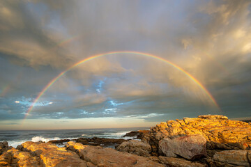 Fototapeta na wymiar Double rainbow and clouds over the ocean