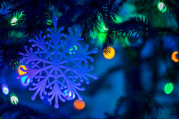 Fototapeta na wymiar blue snowflake on a tree with yellow garlands, horizontal format