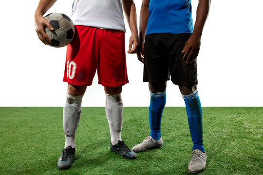 Close up legs of professional soccer, football players fighting for ball on field isolated on white background. Concept of action, motion, high tensioned emotion during game. Cropped image.