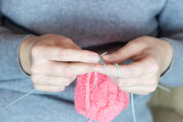 The girl knits with knitting needles