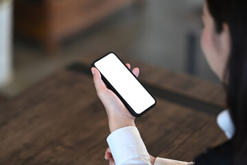 Close up view of businesswoman holding mobile phone with blank screen. Blank screen for graphics display montage.