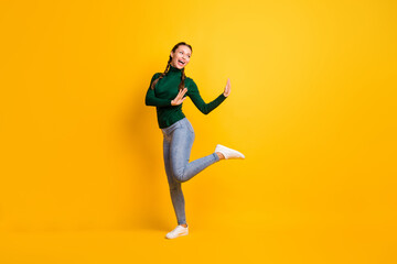 Fototapeta na wymiar Full length body size photo childish girl dancing laughing looking blank space isolated on vibrant yellow color background