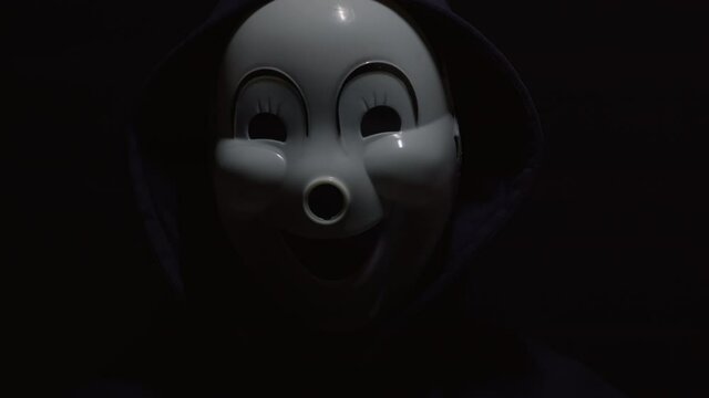 Mysterious man on a black background. Hacker in a mask with a closed face.