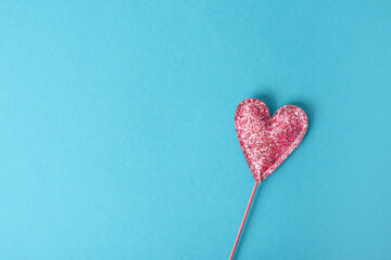 Shiny heart on a blue background. Pink sequins. Valentine's Day. Copy space