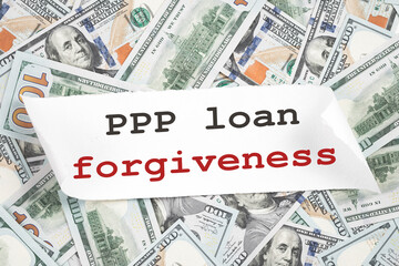 PPP loan forgiveness text note on hundred dollar bill notes. Cash Money background. Small business Paycheck Protection Program. Banking and finance concept