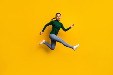 Fototapeta na wymiar Full length body size photo smiling woman jumping high in stylish clothes isolated on vibrant yellow color background