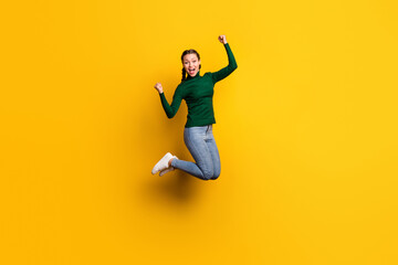 Fototapeta na wymiar Full length body size photo smiling woman jumping high gesturing like winner isolated on bright yellow color background