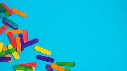 Colored popsicle sticks on blue paper