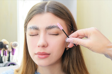 Beautiful young woman got correction of eyebrows in a beauty salon