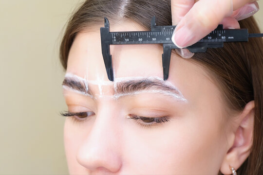 Changing Shape Of The Eyebrows. Eyebrow Stylist Measuring Eyebrow With Ruler.