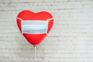 Red heart baloon in medical mask, Valentine's day during pandemic concept