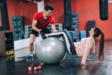 Fitness instructor with girl on training in fitness center